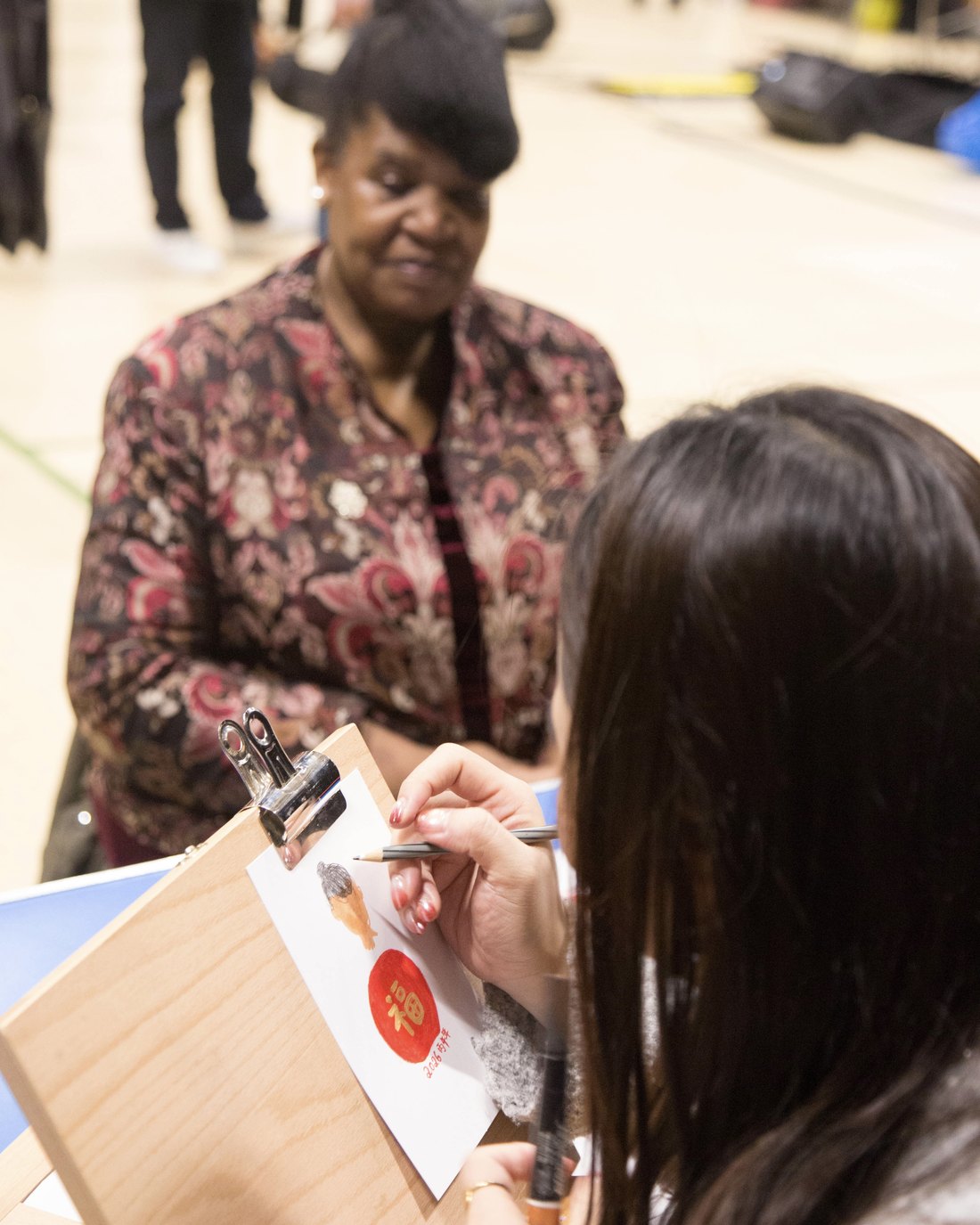 Hiumandy drawing a live portrait of a guest at an event